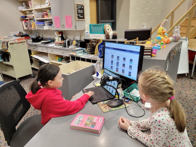 student checking out another’s books in the library