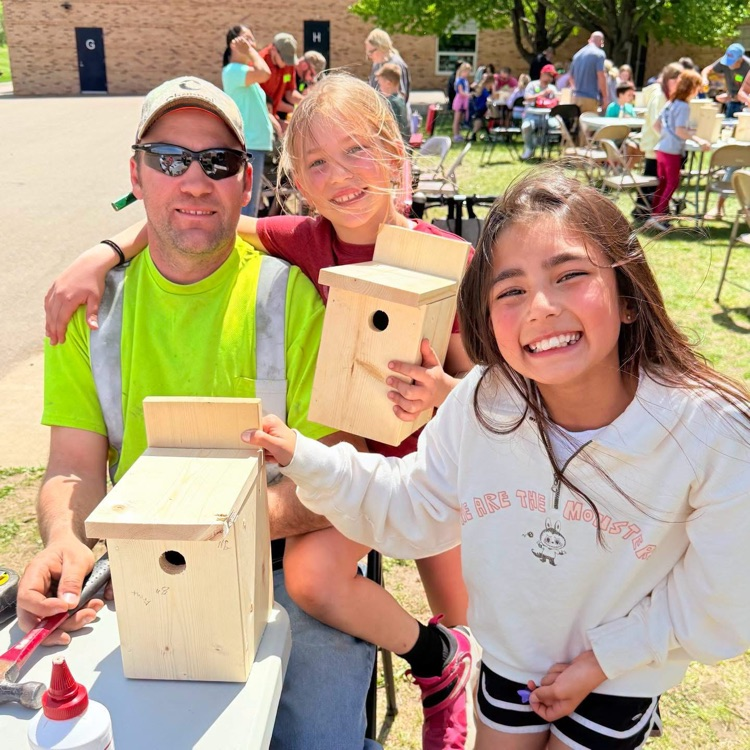 students woodworking outside with volunteers