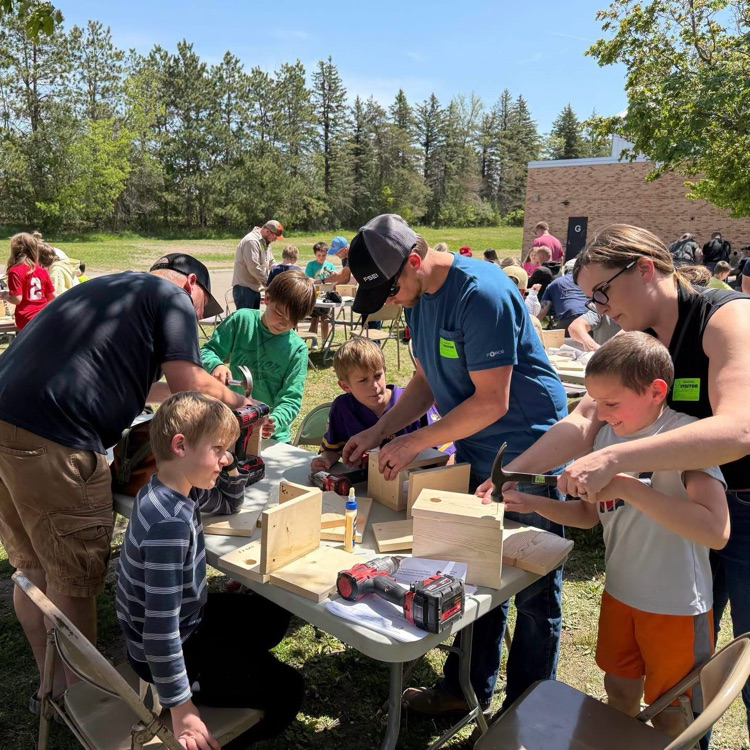 students woodworking outside with volunteers