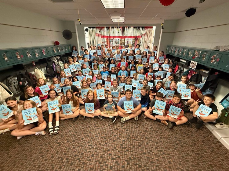 students holding new books