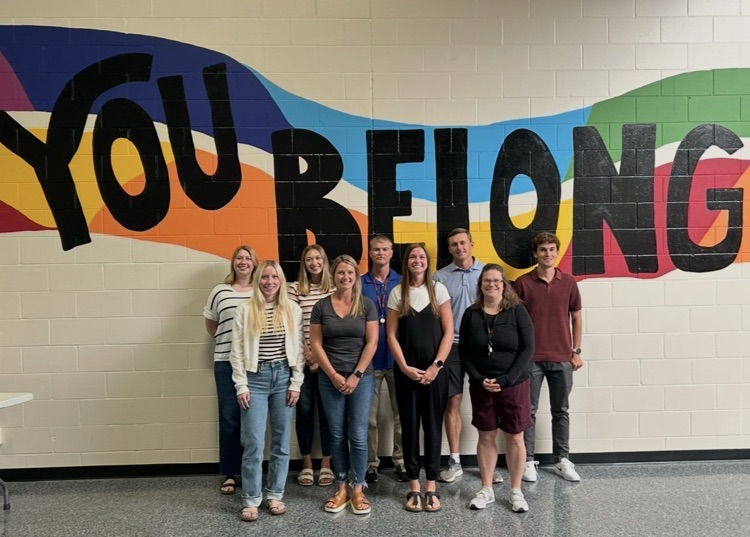 teachers standing together in front of “You Belong” mural
