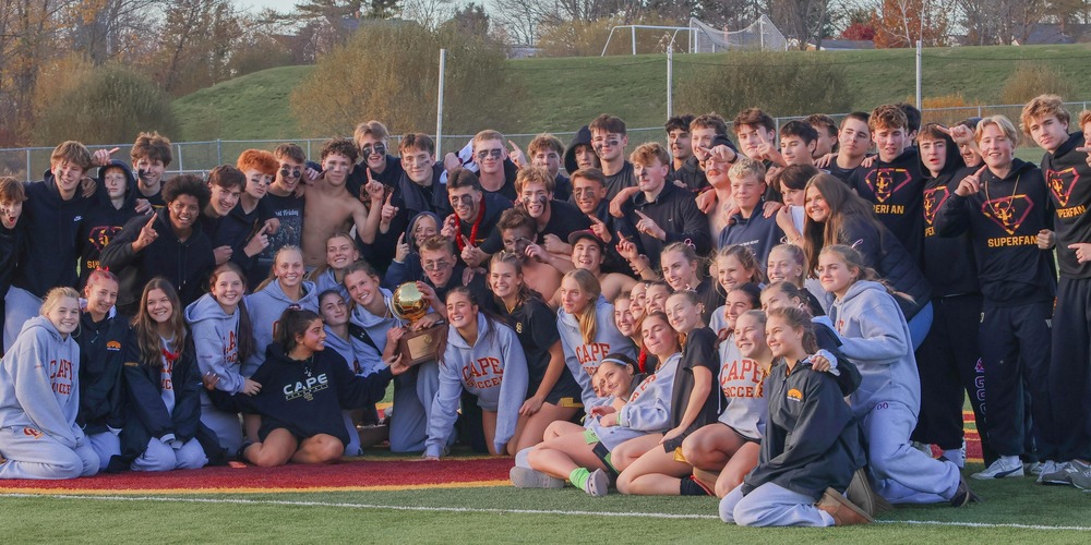 cape elizabeth girls high school soccer team posing with gold championship ball and all their fans