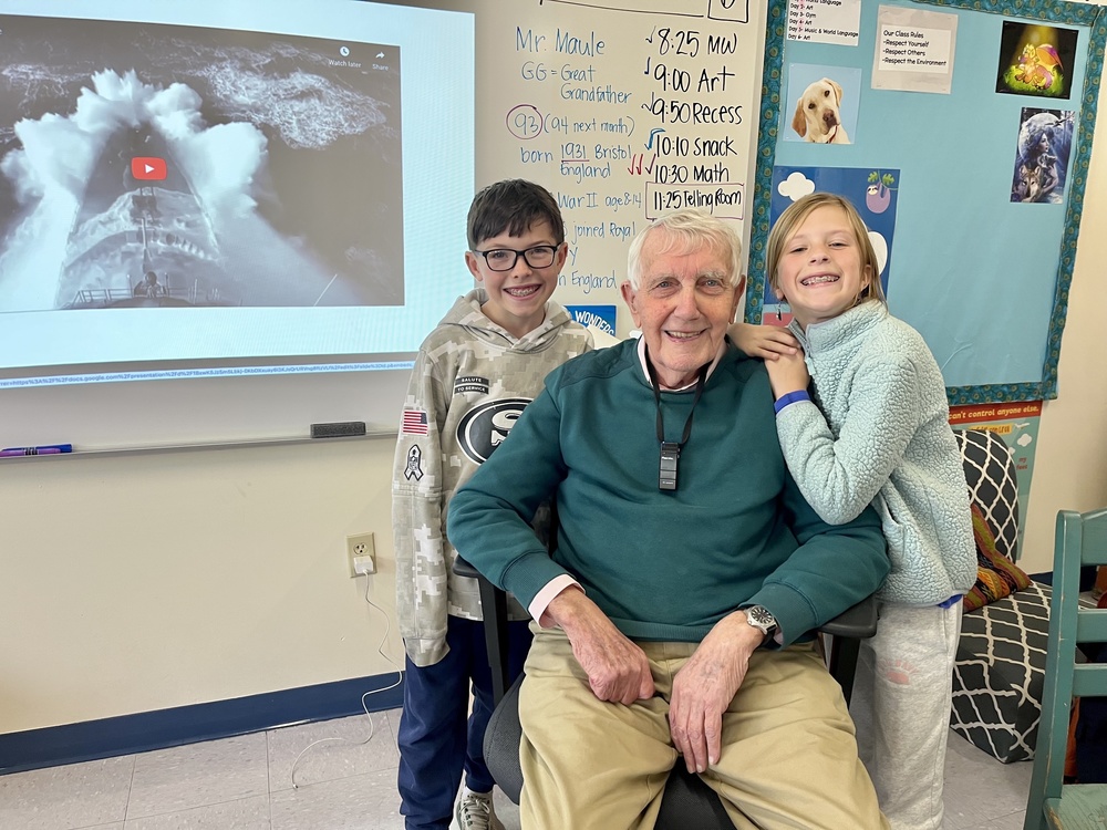  2 students with their grandfather who is a war veteran