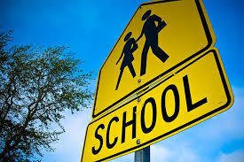 School crossing sign. School written out with a sign of stick people walking above the word.