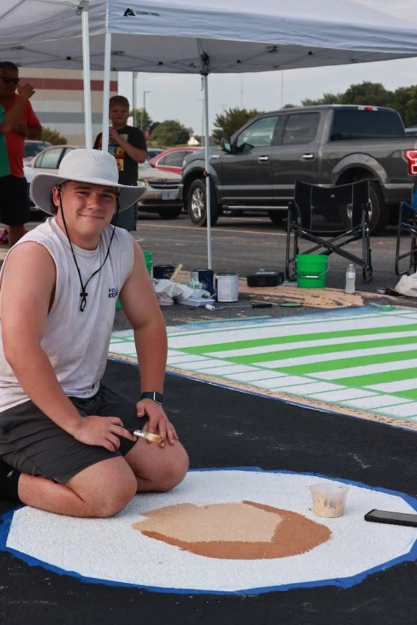 student works on artwork on his parking spot