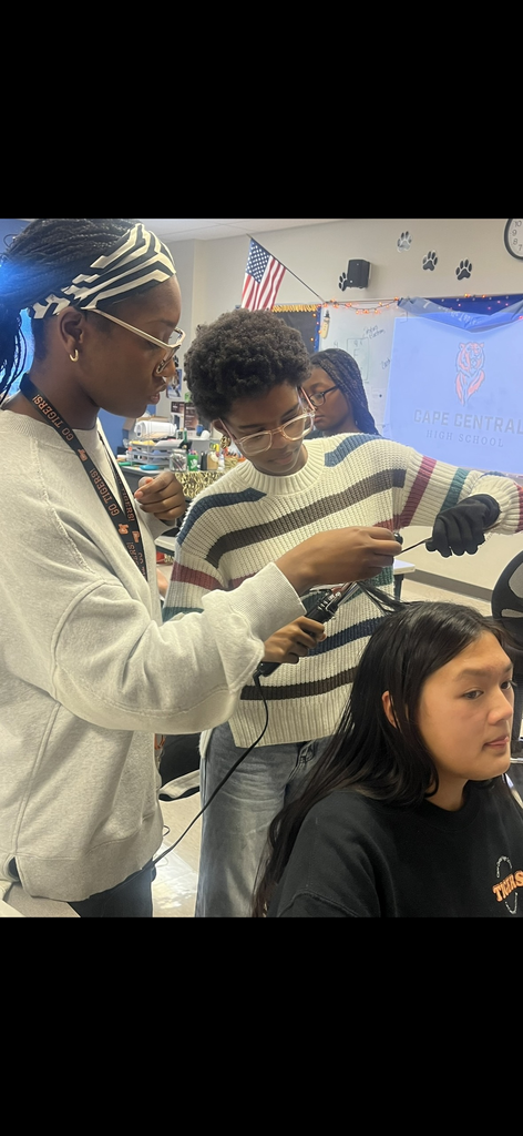 Students practice curling hair