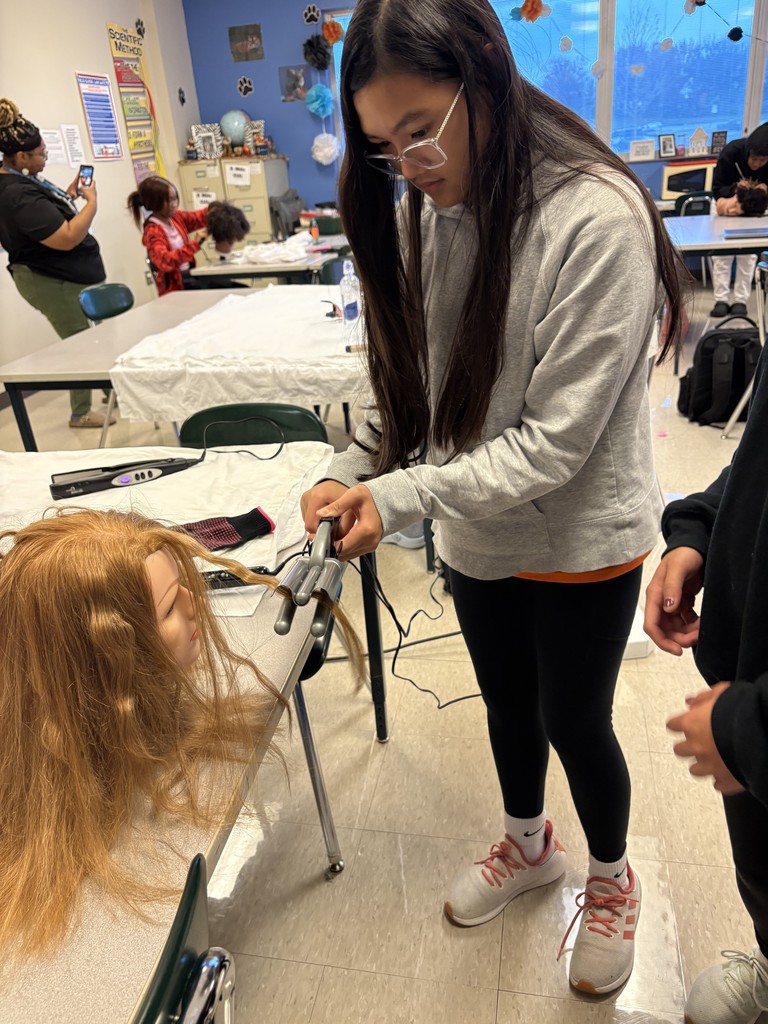 Students practice curling hair