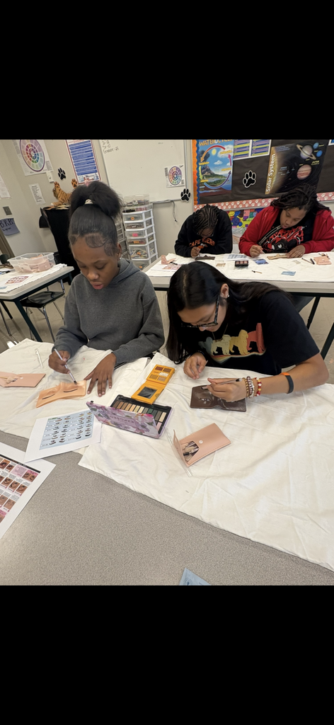 Students practice eye shadow and lashes.