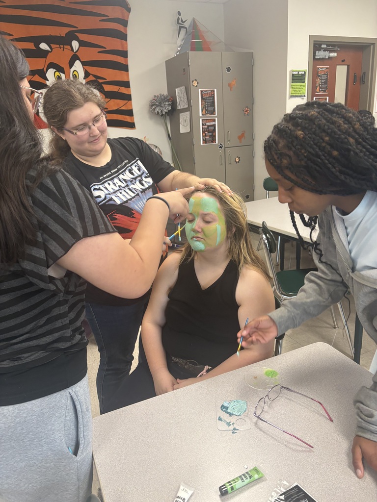 Students work on a student's face paint