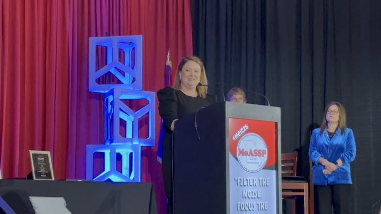 Mrs. Russell speaking at a podium