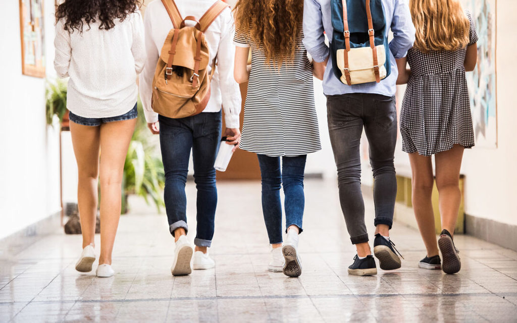 high school students walking down a hallway