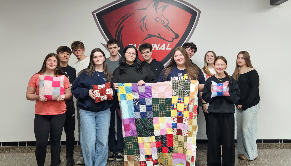 Printmaking Art Class displays their strong classwork with a homemade quilt and pillows. 