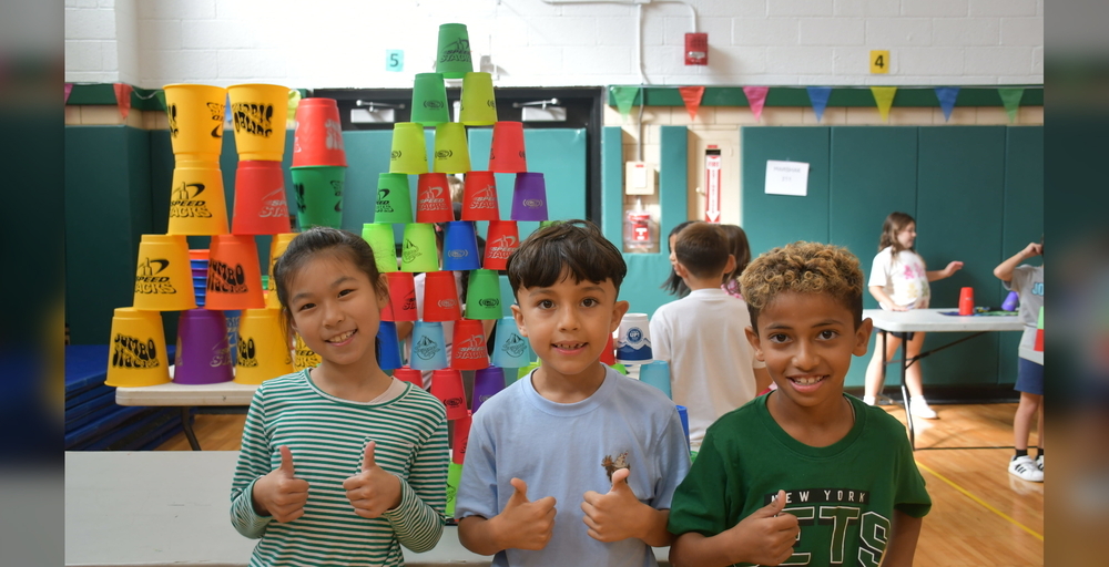 students in oclorful classroom with stacks cups piled up