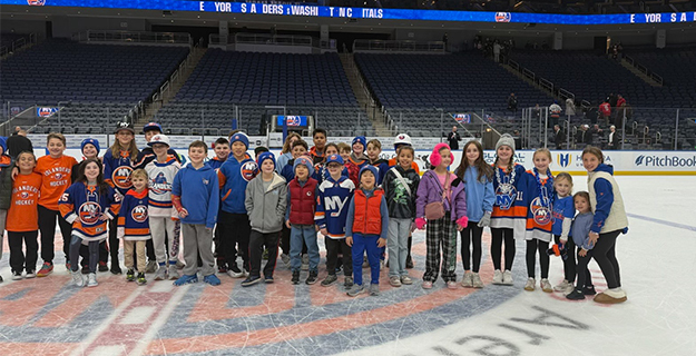 Students smiling together in hockey rink.