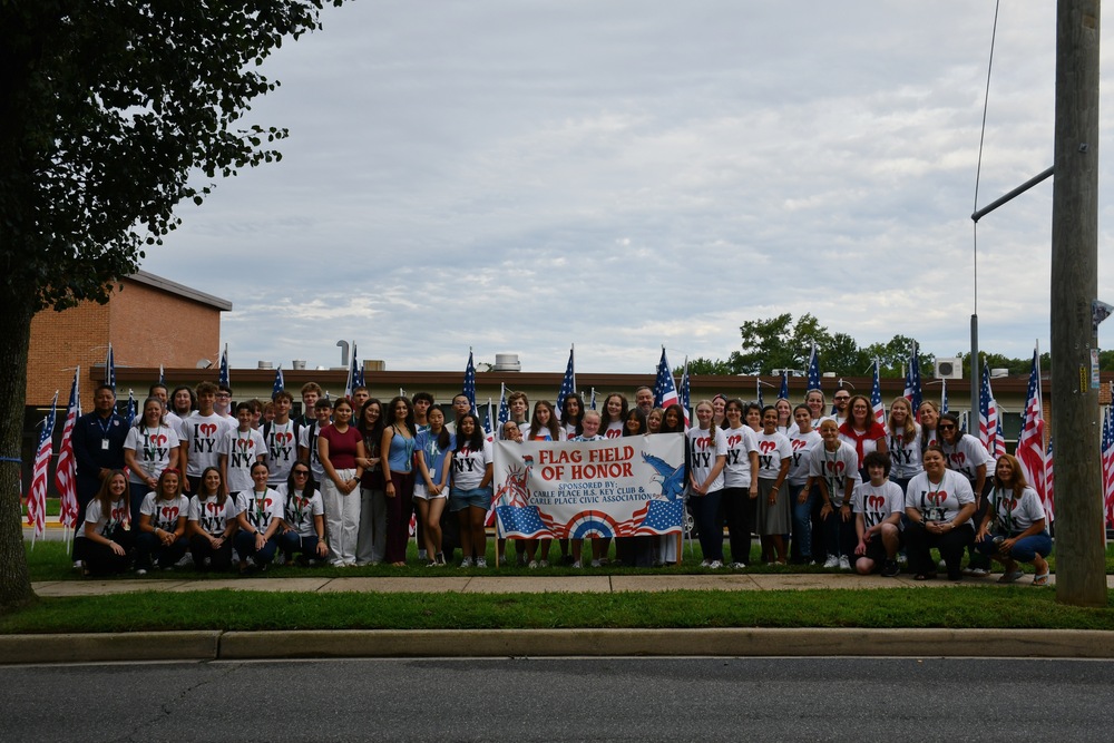 Students standing outside holding banner.