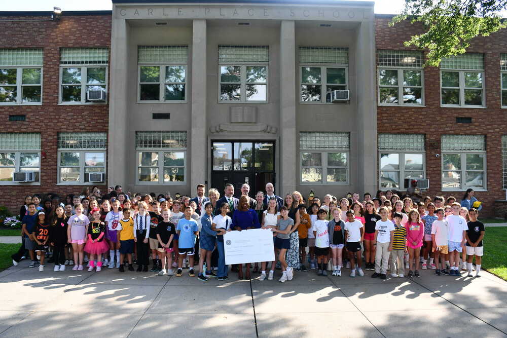 Legislator taking photo outside Rushmore building with students.