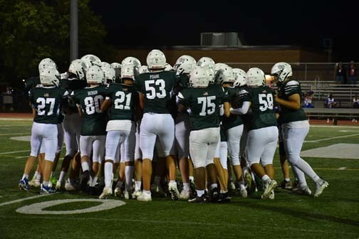 Carle Place football team huddled together.