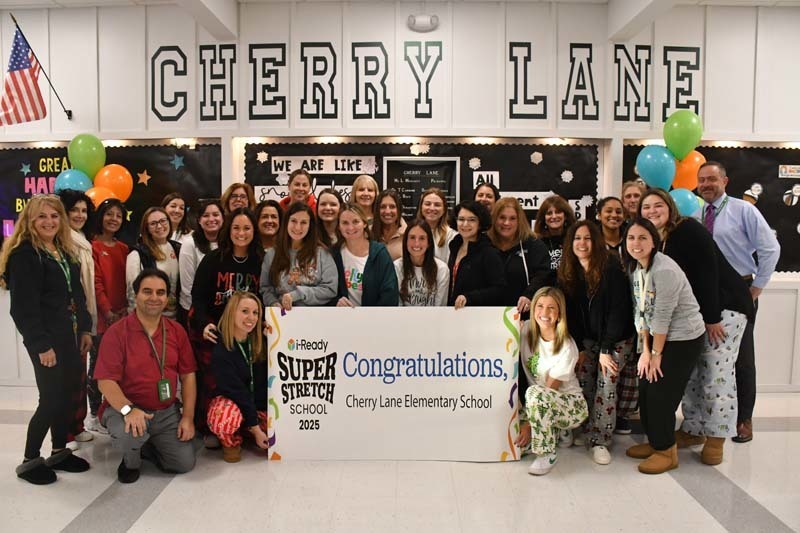 Cherry Lane staff smiling by poster.