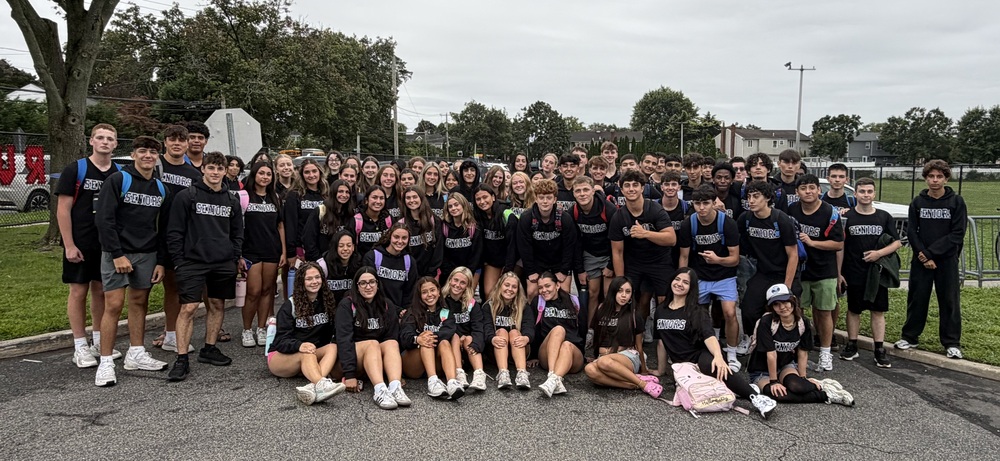 Group photo of high school students outside by field.