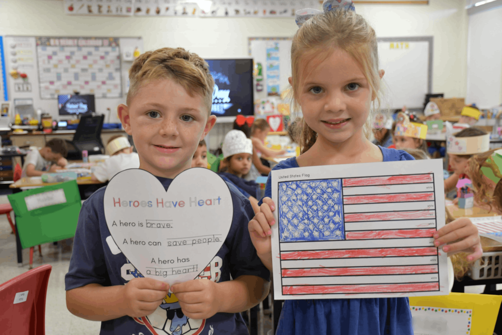 Students holding cutout art they made.