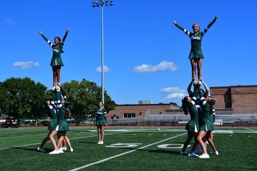 Cheerleading team stacking each other on their shoulders.