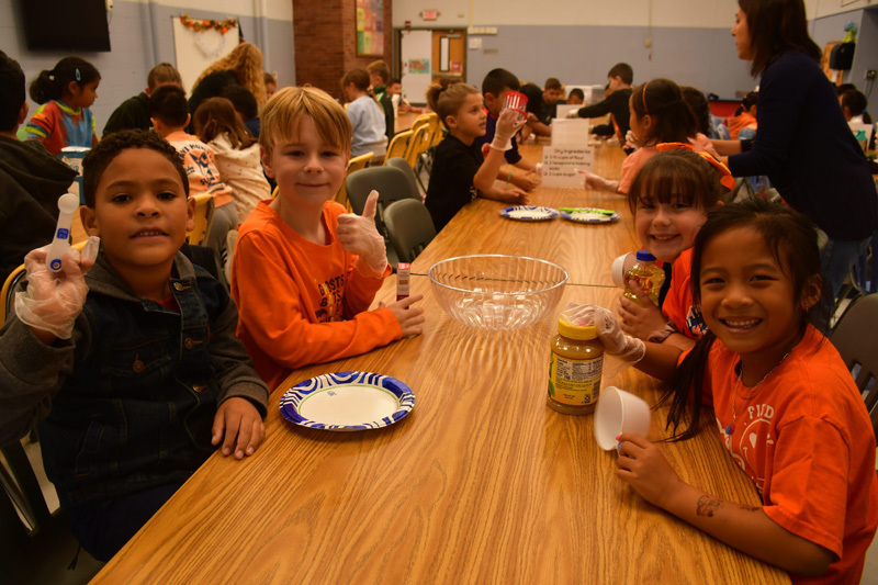 students in classroom at table with food