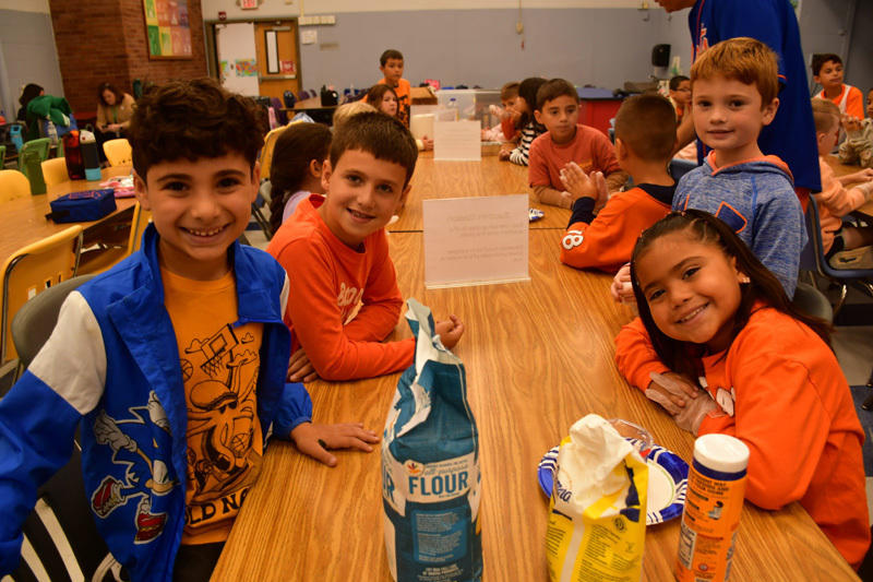 students in classroom at table with food