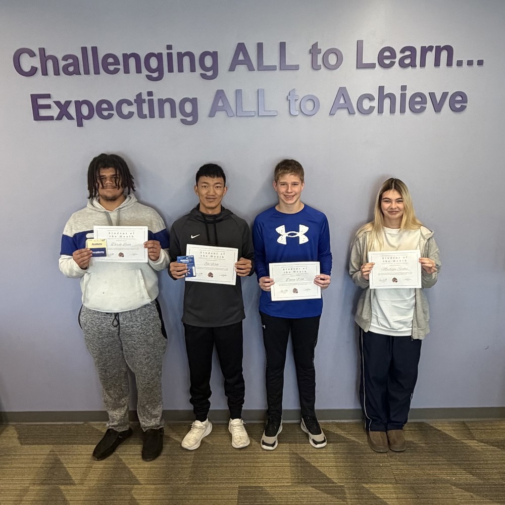 the 4 students of the month smile for a photo holding certificates