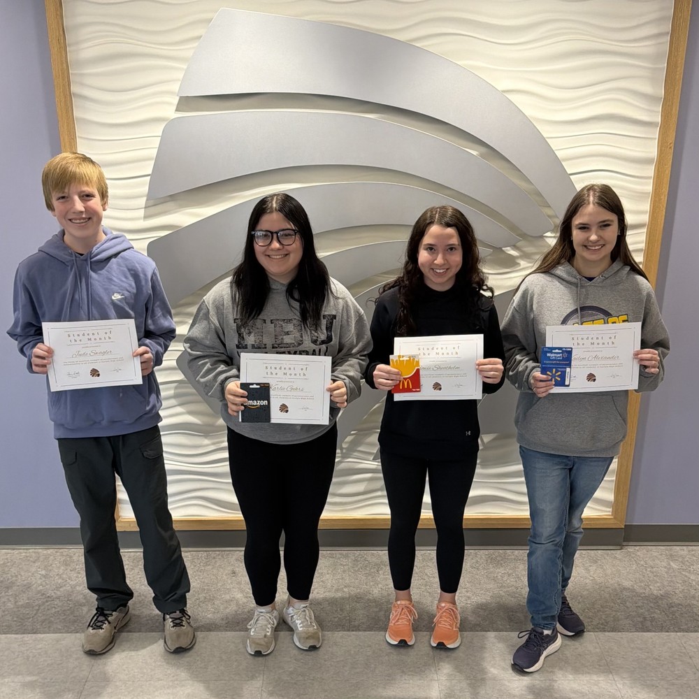 a photo of 4 student of the month winners holding certificates and a gift card winnings
