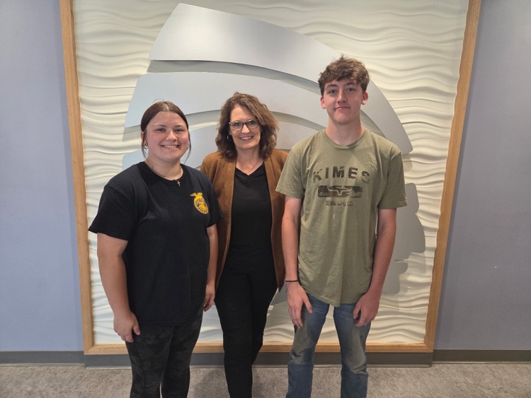 Lori and 2 students smile together for a photo in the CHS lobby