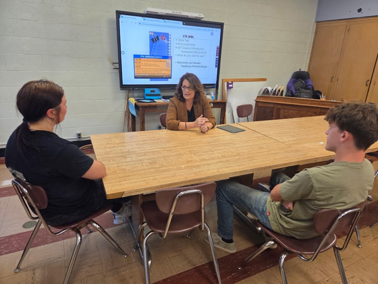 2 students listen to Lori talk about her business