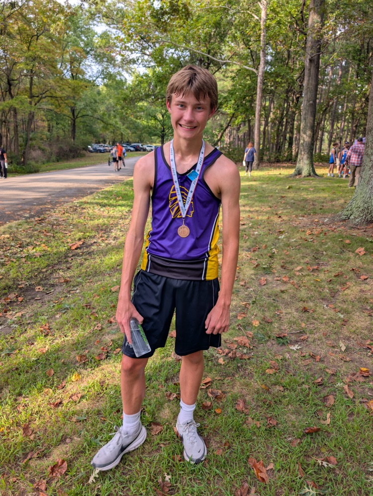 benson smiles for a photo with his medal