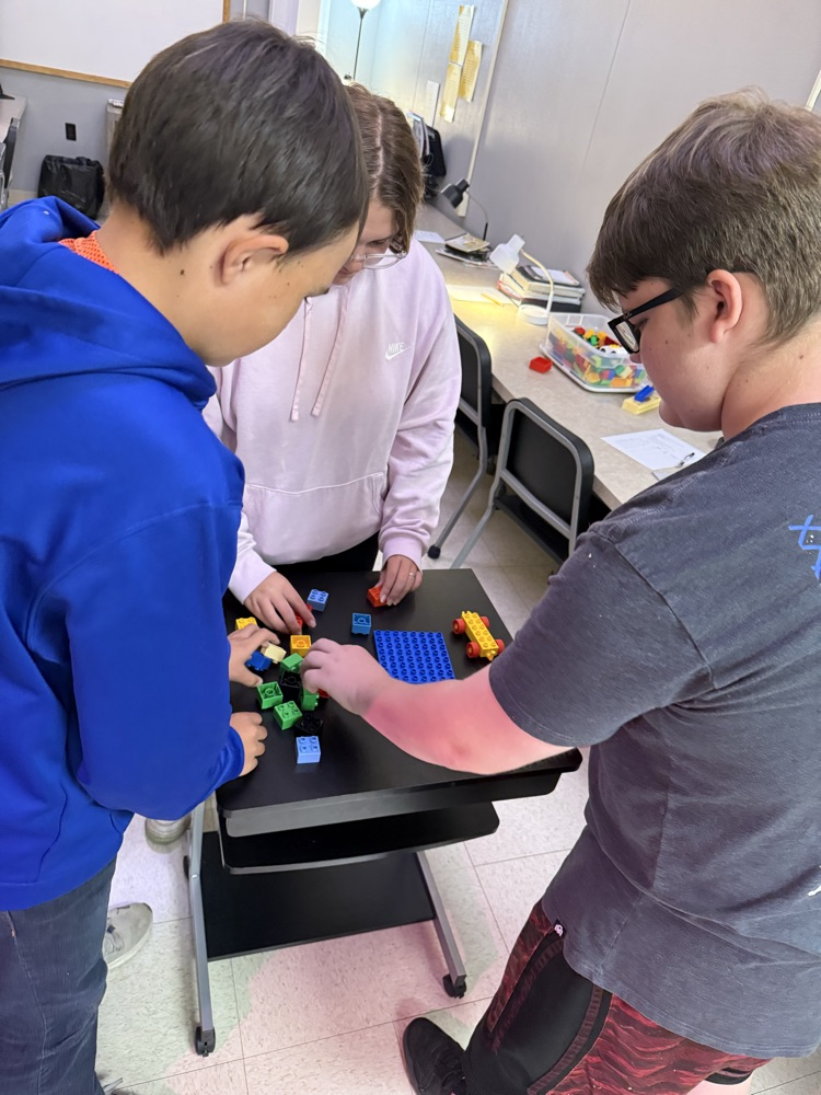3 students work with legos