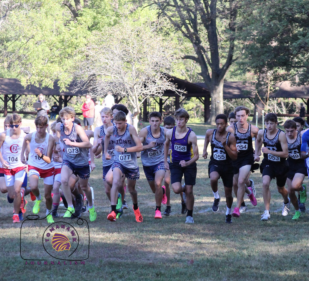 Multiple cross country runners start the race.