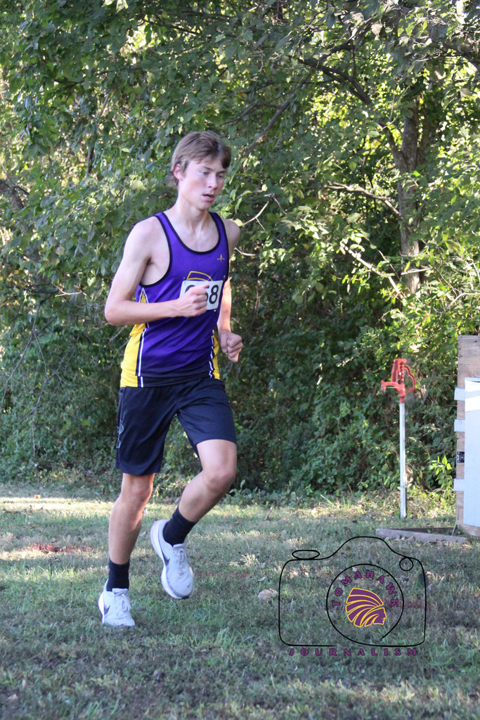Benson runs through a wooded area.