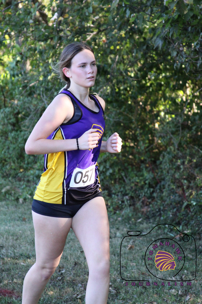 Peyton runs through a wooded area.