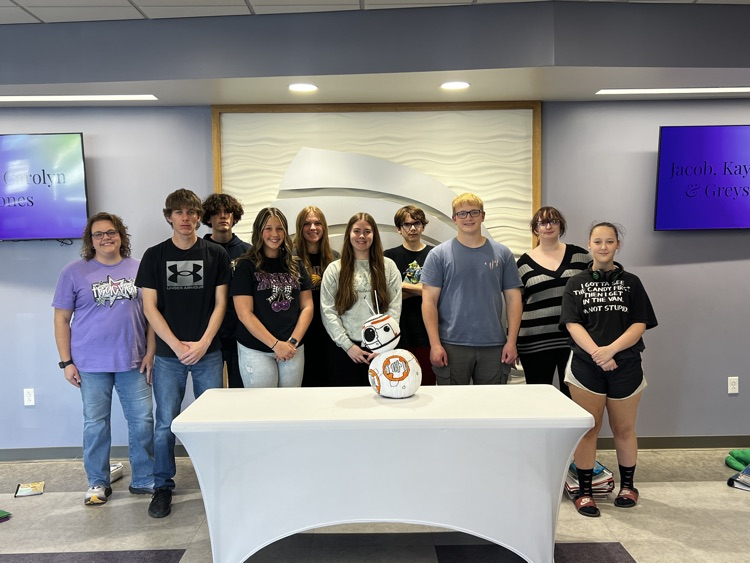 students pose by the bb-8 pumpkin