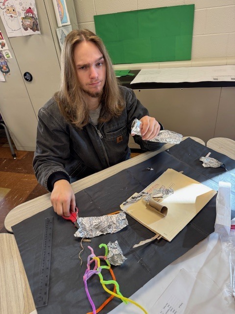 A male student raises an eyebrow at the project