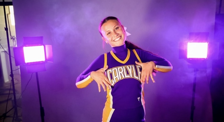 female cheerleader standing in purple smoke