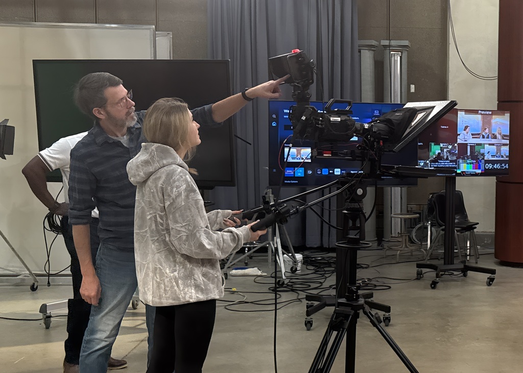  SIUE instructor Cory Byers teaches senior Addie Gansauer to position the camera and teleprompter.