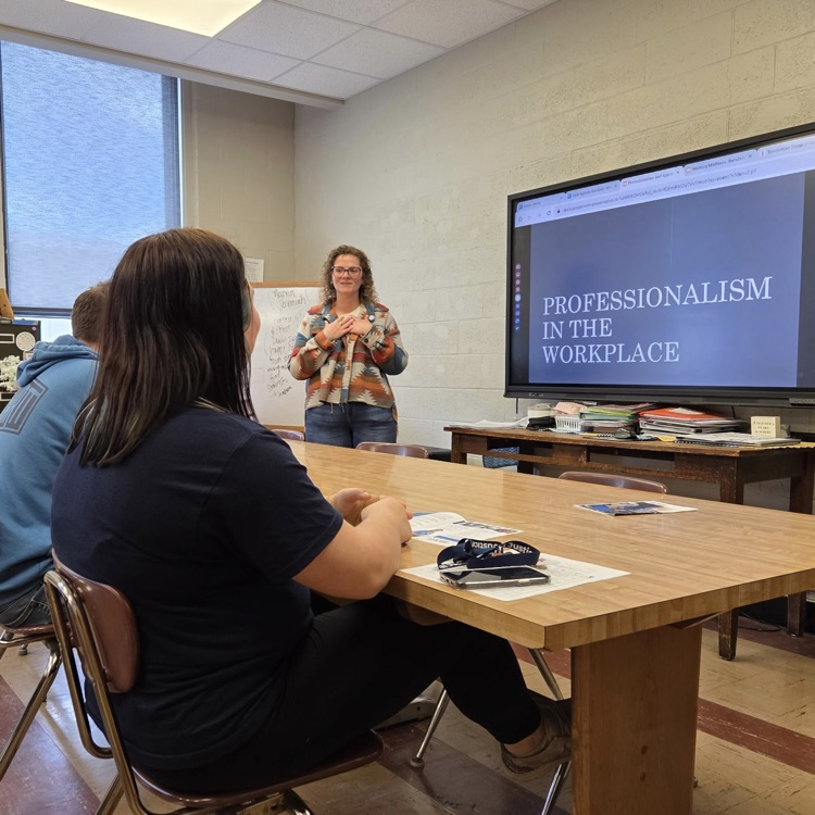 photo of 2 students listening to guest speaker