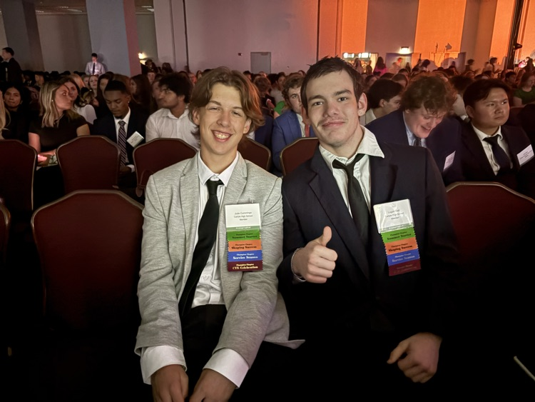 2 students smile at general session