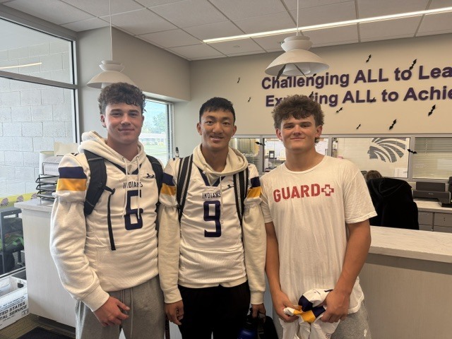 3 boys group together for a photo in the CHS front office.