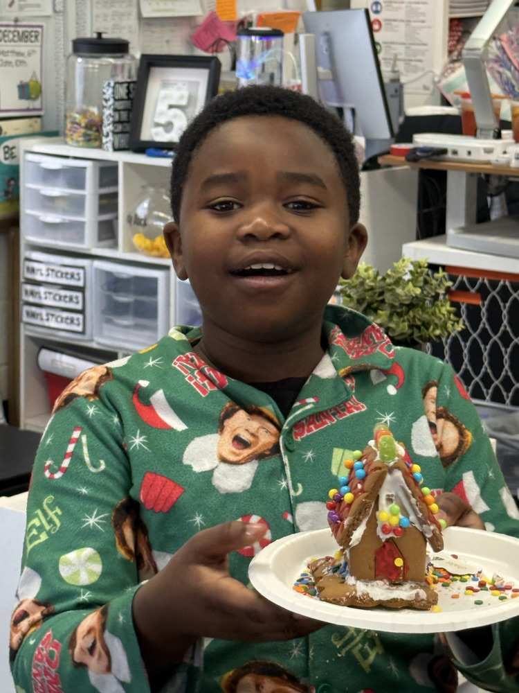 student with gingerbread house 