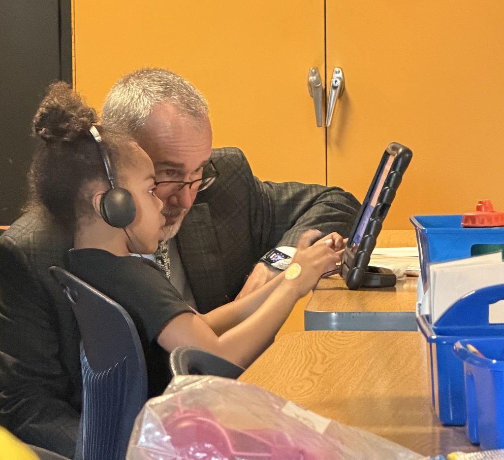 superintendent and student looking at device