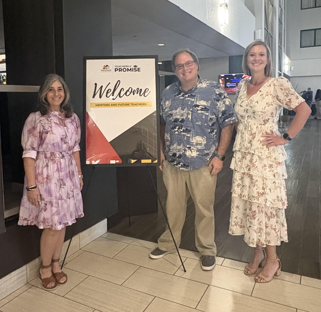 three Caroline teachers with the event poster