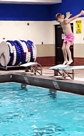 boy jumping into pool