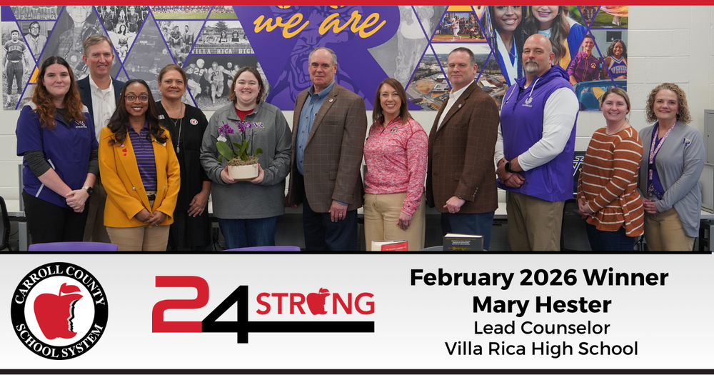 Mary Hester receives the February 2026 24STRONG Award from Superintendent Scott Cowart, and district and school administrators