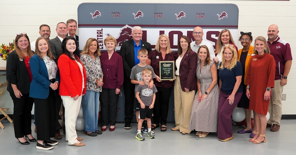 gassp principal of the year colleen jones is surrounded by co workers, school and district leadership, family as she is presented a plaque