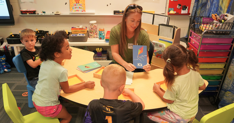a teaching works with children to learn the letter K